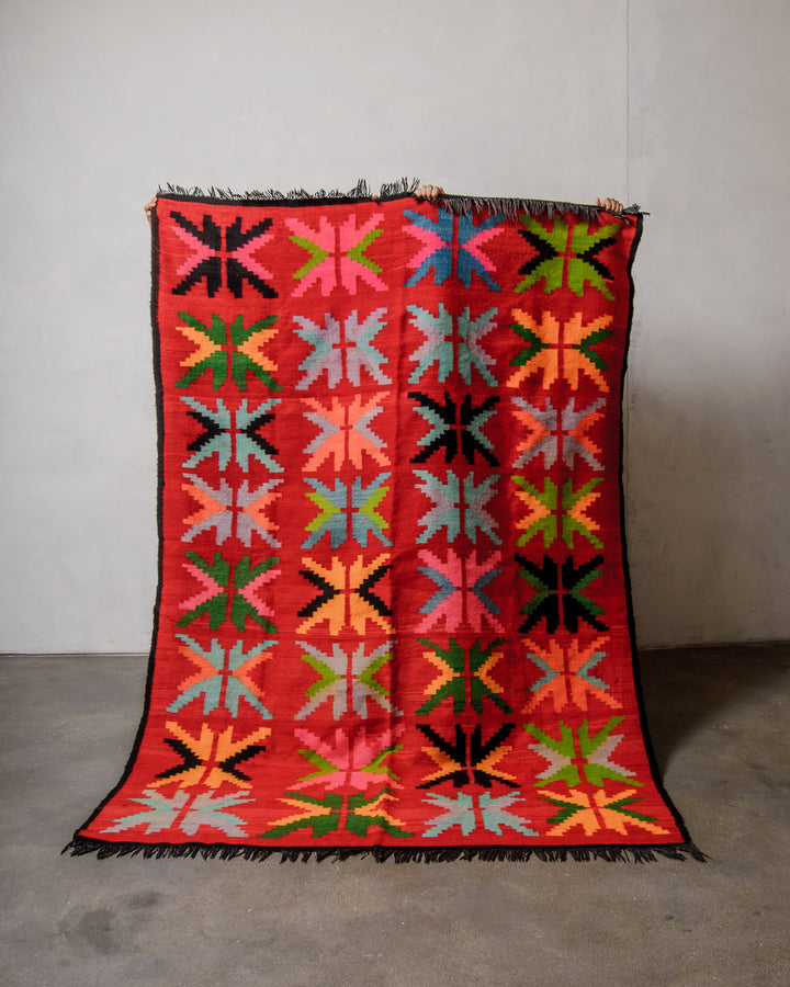 Colorful geometric patterned rug on a plain background