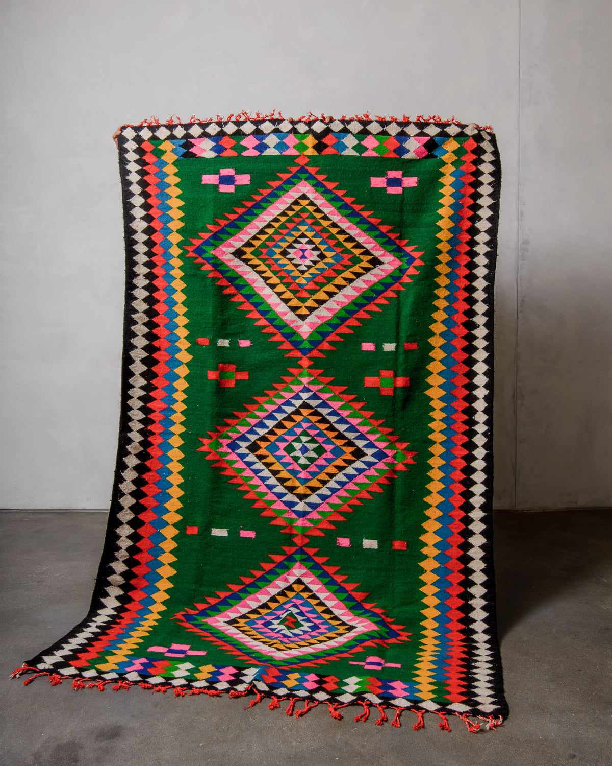 Colorful geometric patterned rug on a plain background