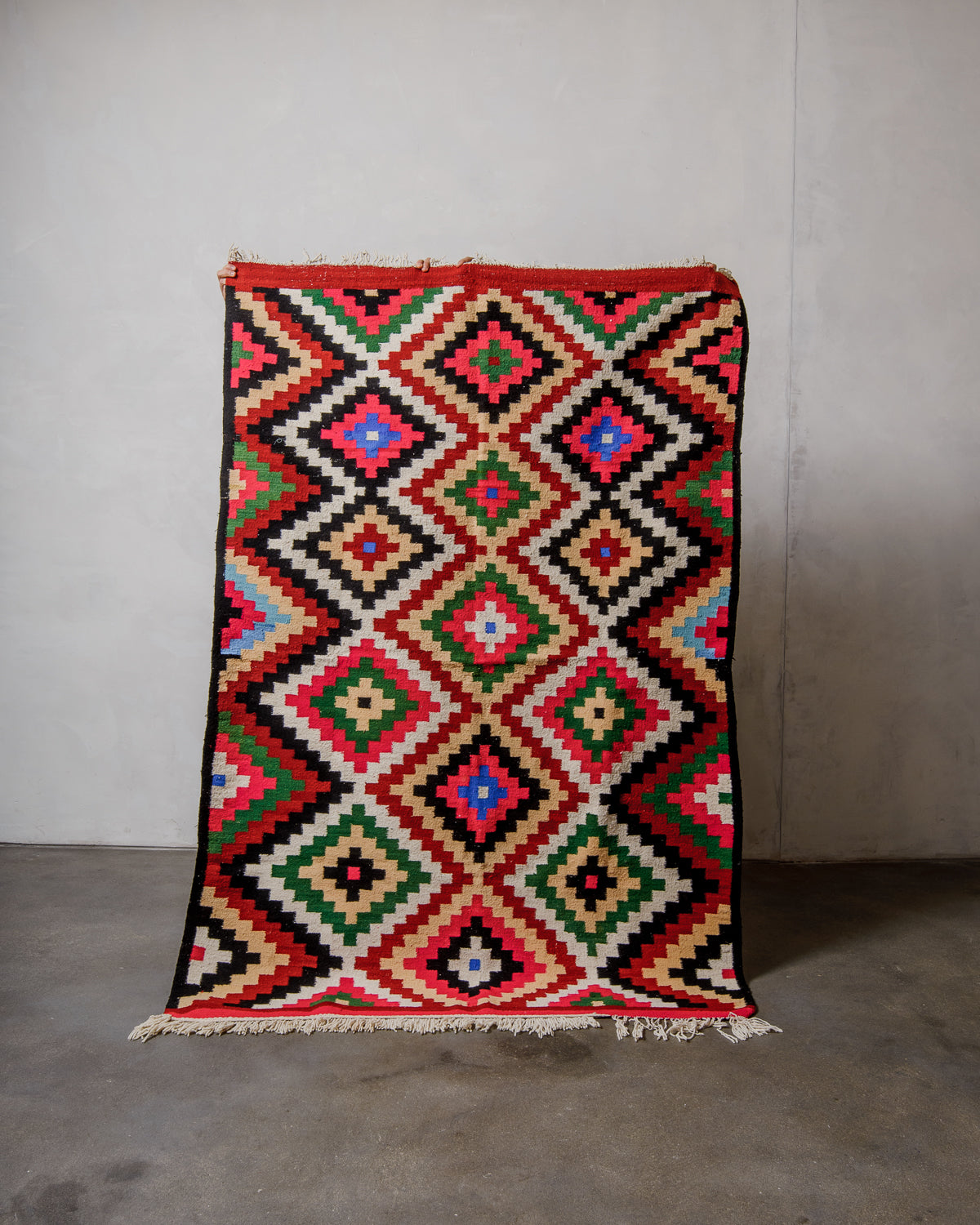 Colorful geometric patterned rug on a plain background