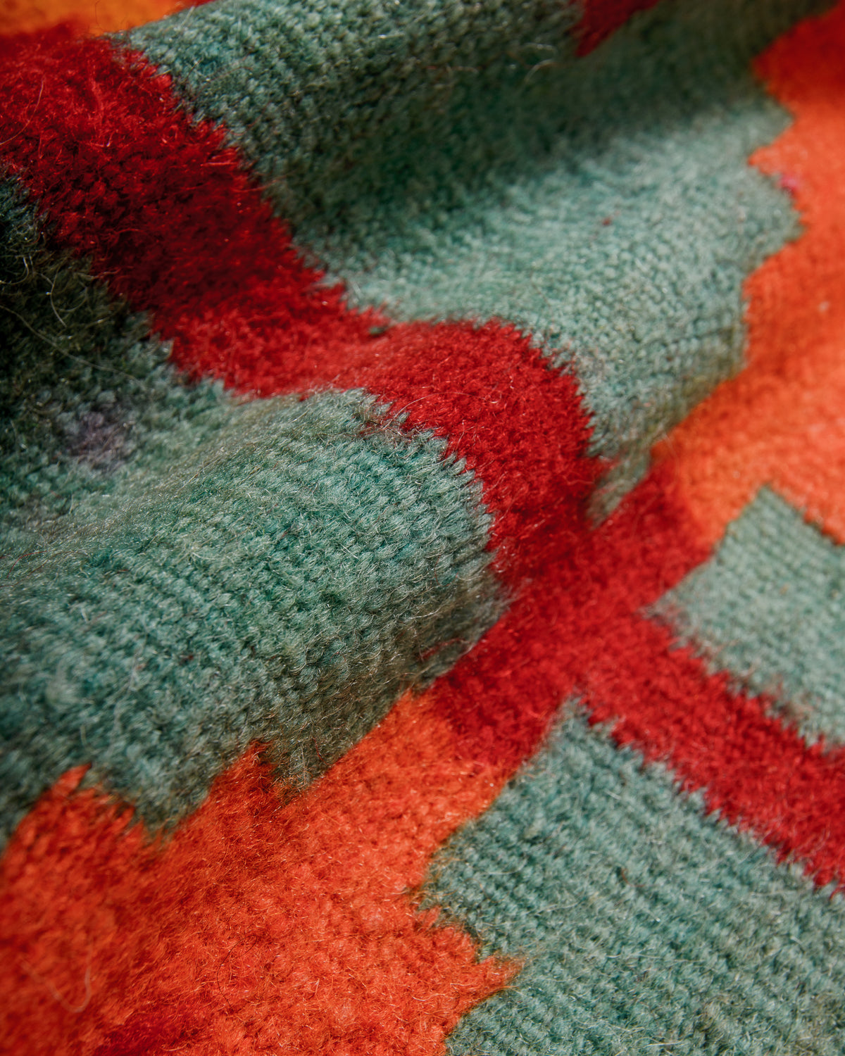 Close-up of a textured fabric with red and green pattern