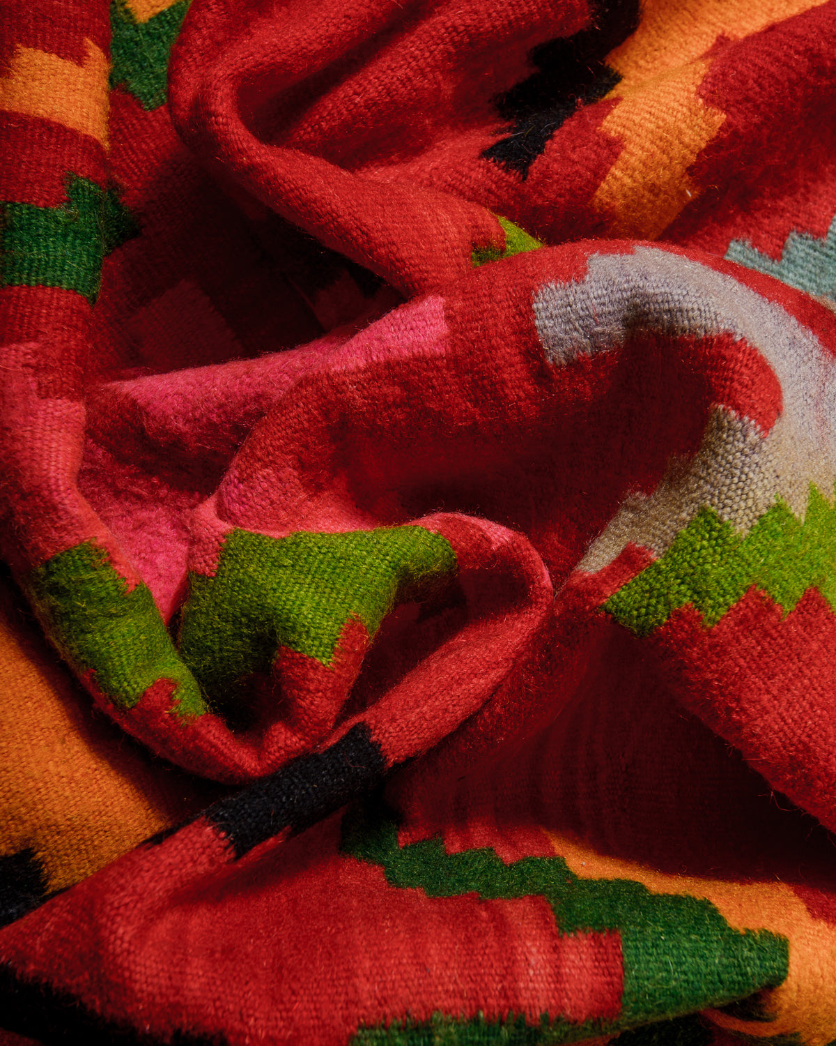 Close-up of a colorful patterned wool with red, green, and orange colors.