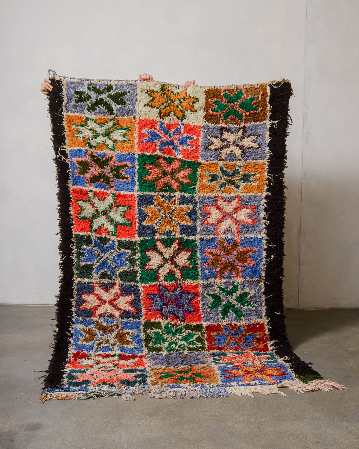 Multicoloured geometric patterned rug on a plain background