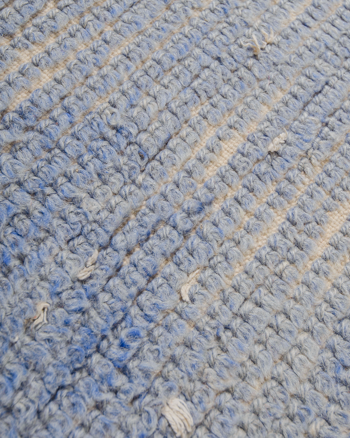 Close-up of textured blue and cream wool of rug