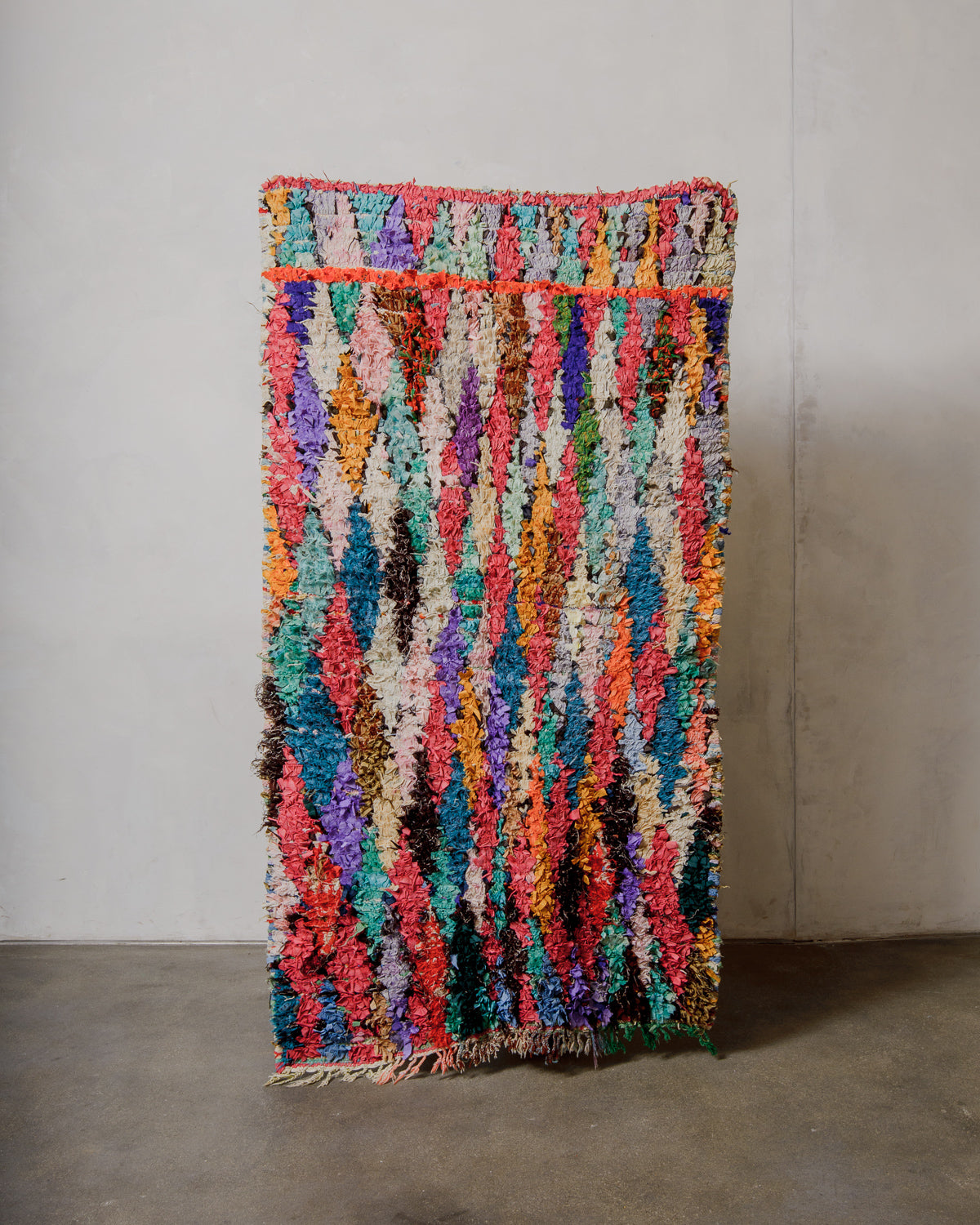 Multicoloured textured rug on a plain background