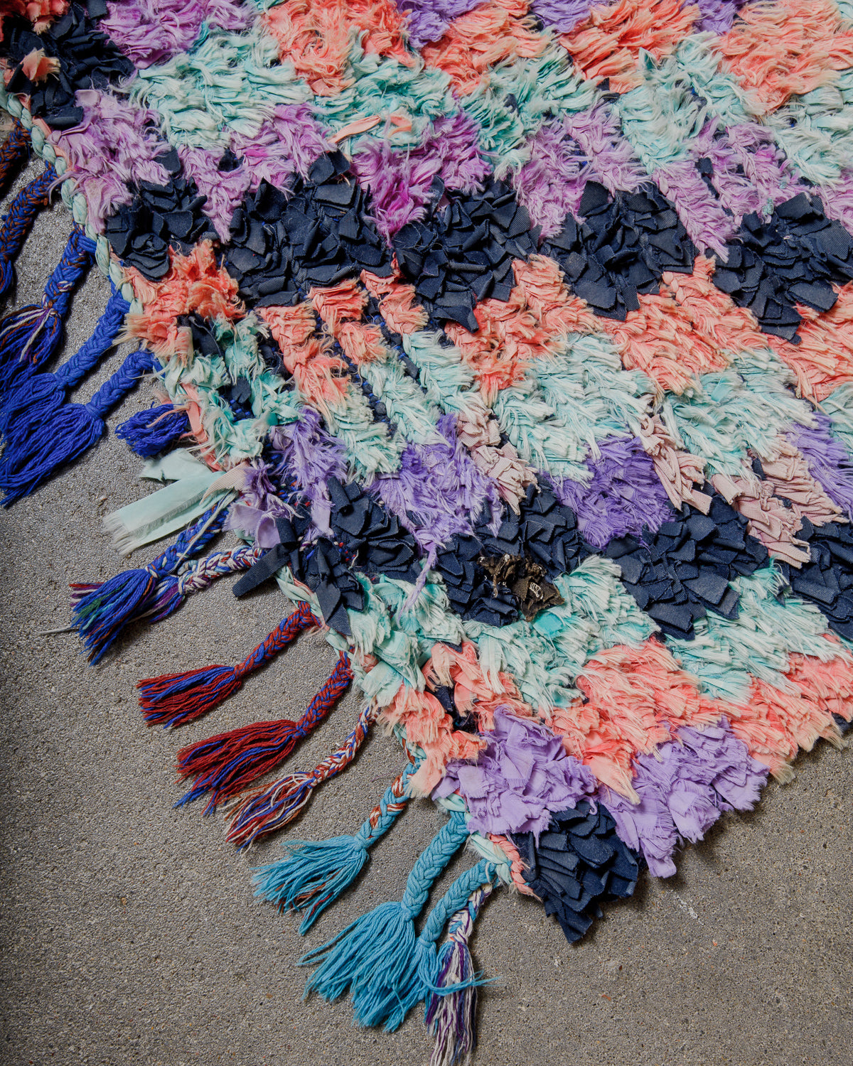 Colourful textured rug with tassels on a neutral background