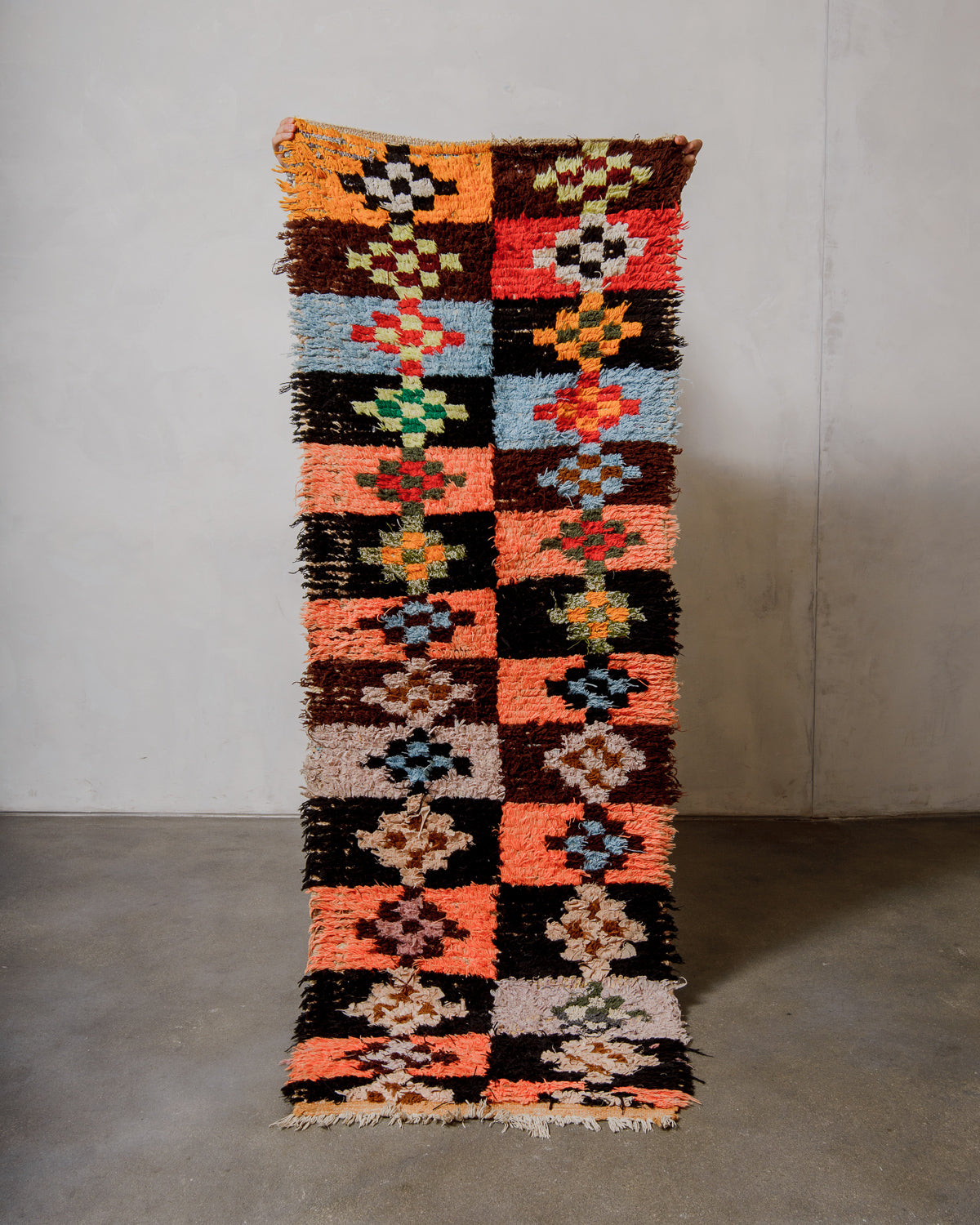Colourful patterned rug on a plain background