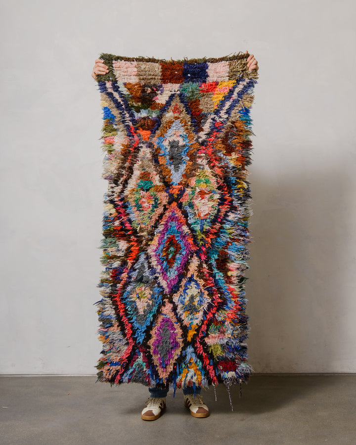 Multicolored textured rug with geometric pattern on a plain background