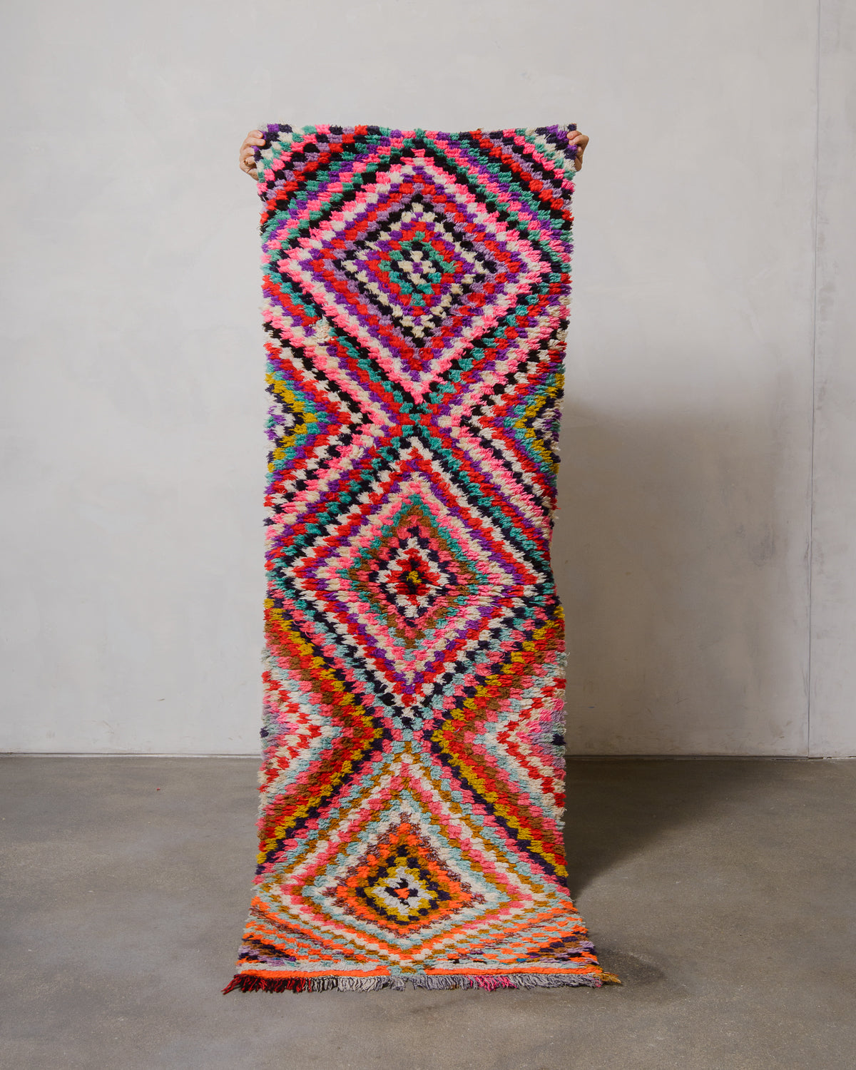 Colorful geometric-patterned rug on a plain background