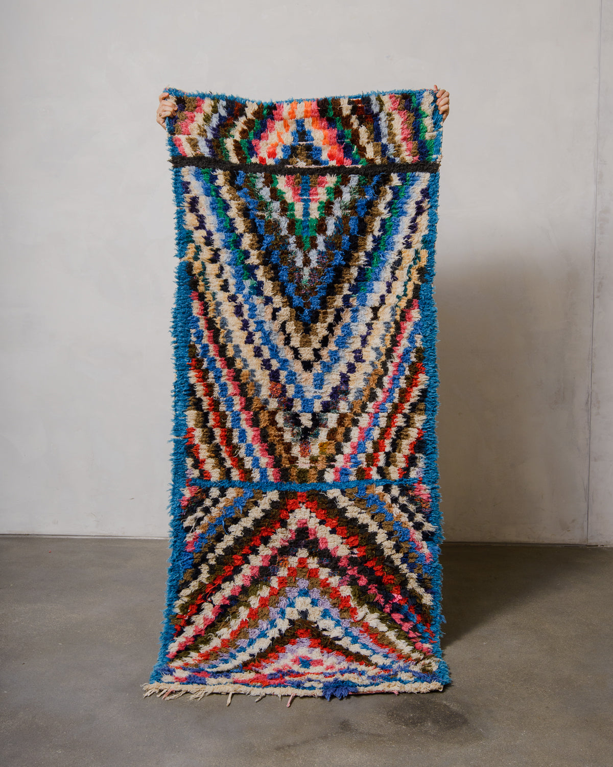 Multicolored geometric patterned rug on a plain background