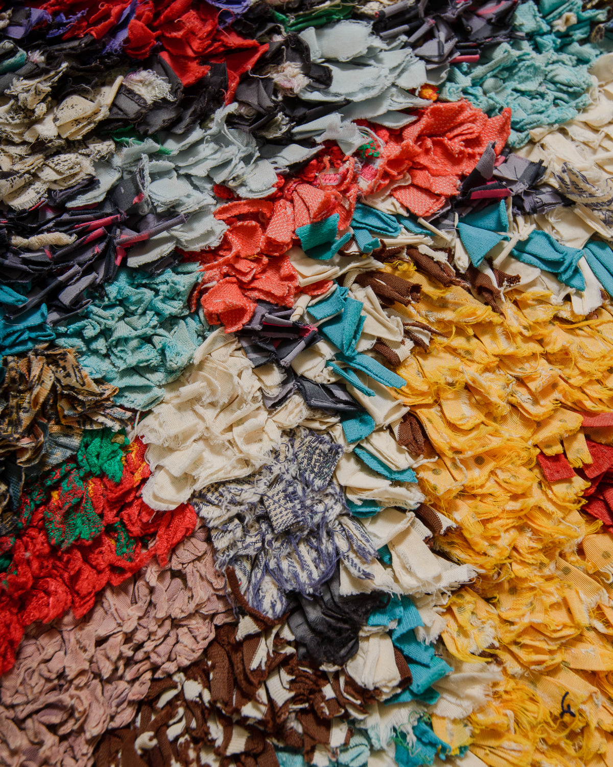 Multicolored textured fabric with various colors including red, blue, green, and yellow.