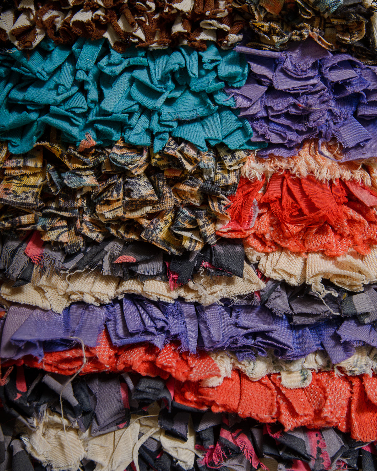 Colorful woven rug with various fabric pieces