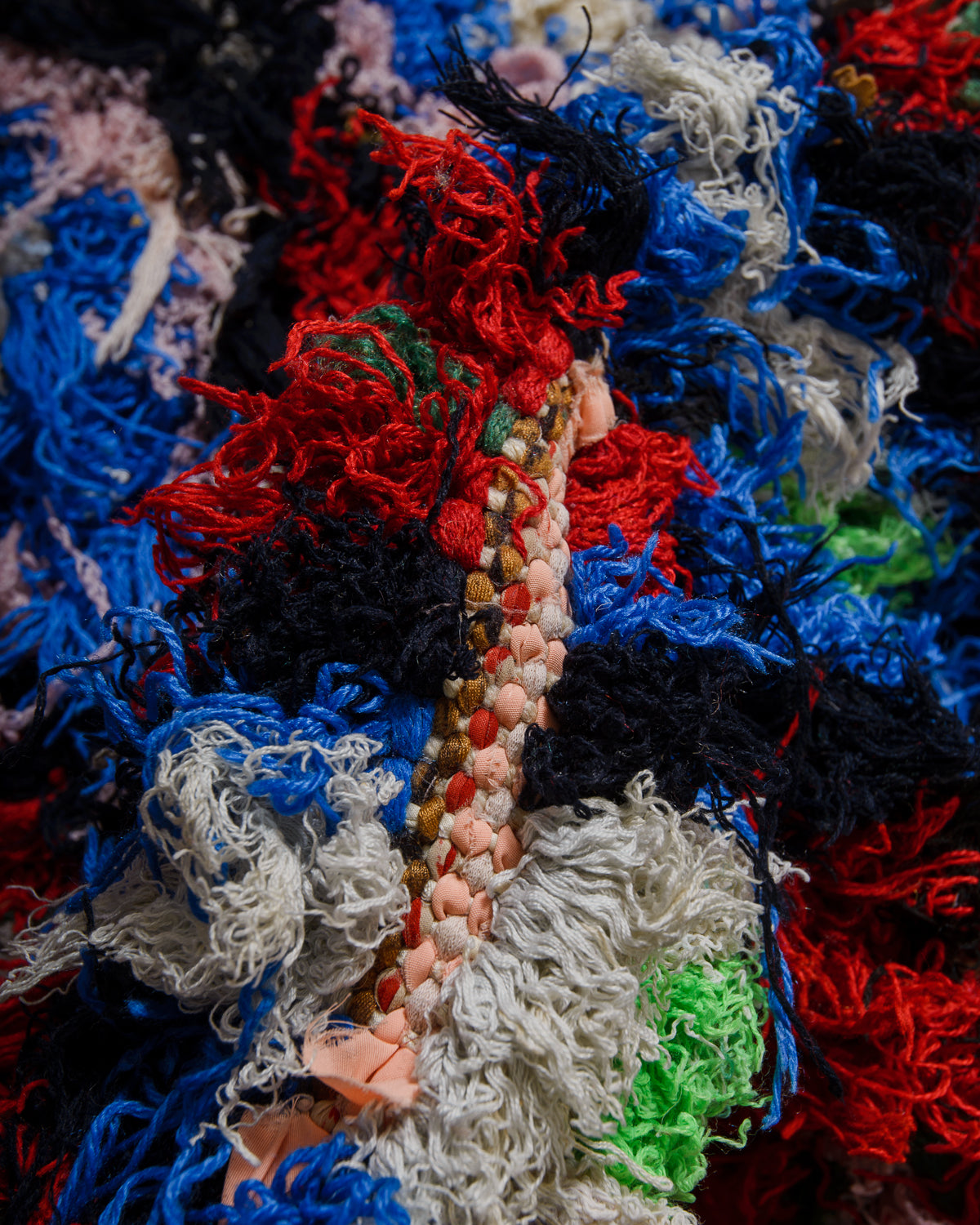 Close-up of a textured fabric rug with multicolor yarns