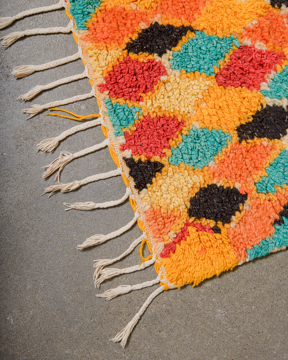 Colorful woven rug with geometric pattern on a gray surface
