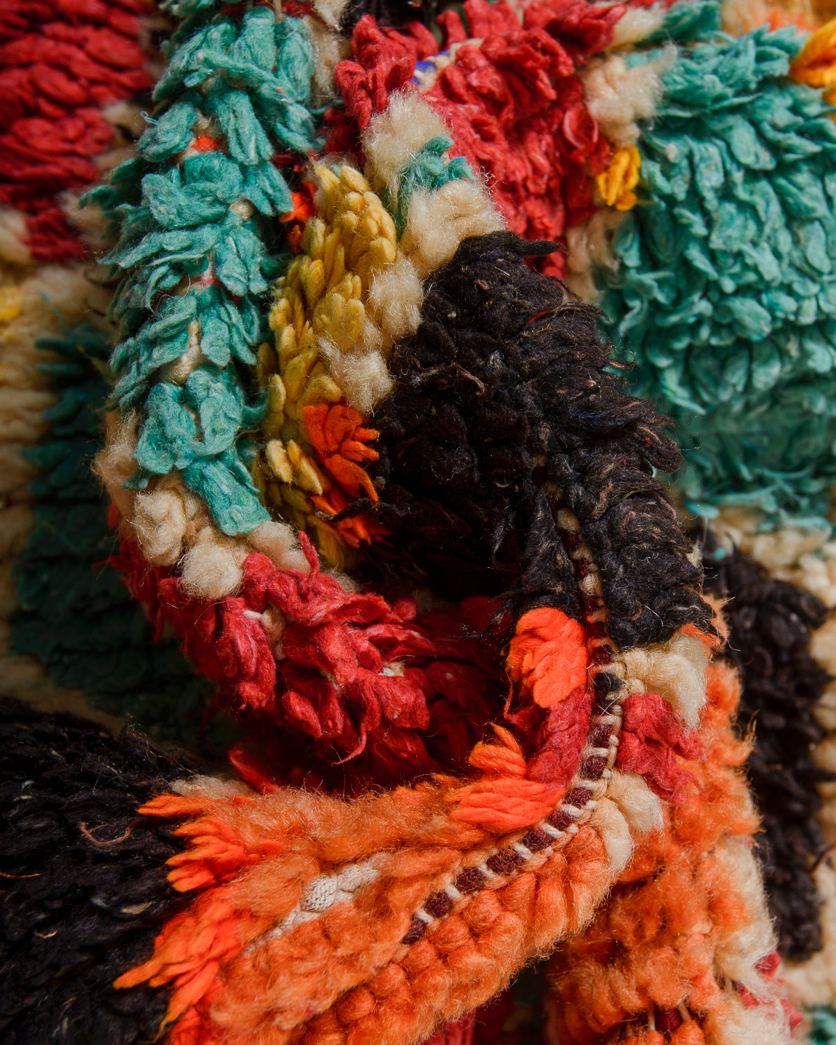 Close-up of a colorful woven textile with various patterns and textures.