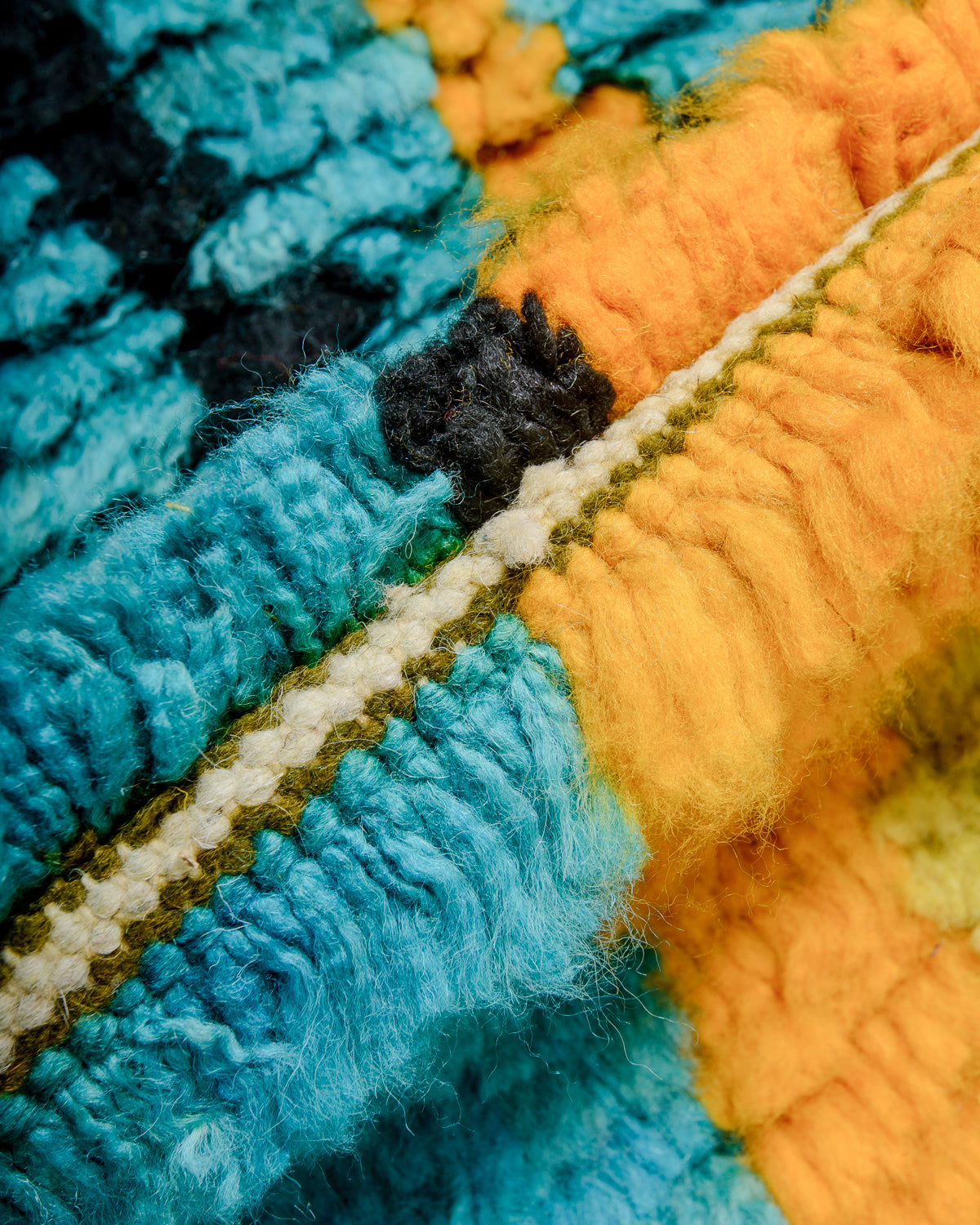 Detail of colourful berber rug showing the density of the knots and the length of the wool.