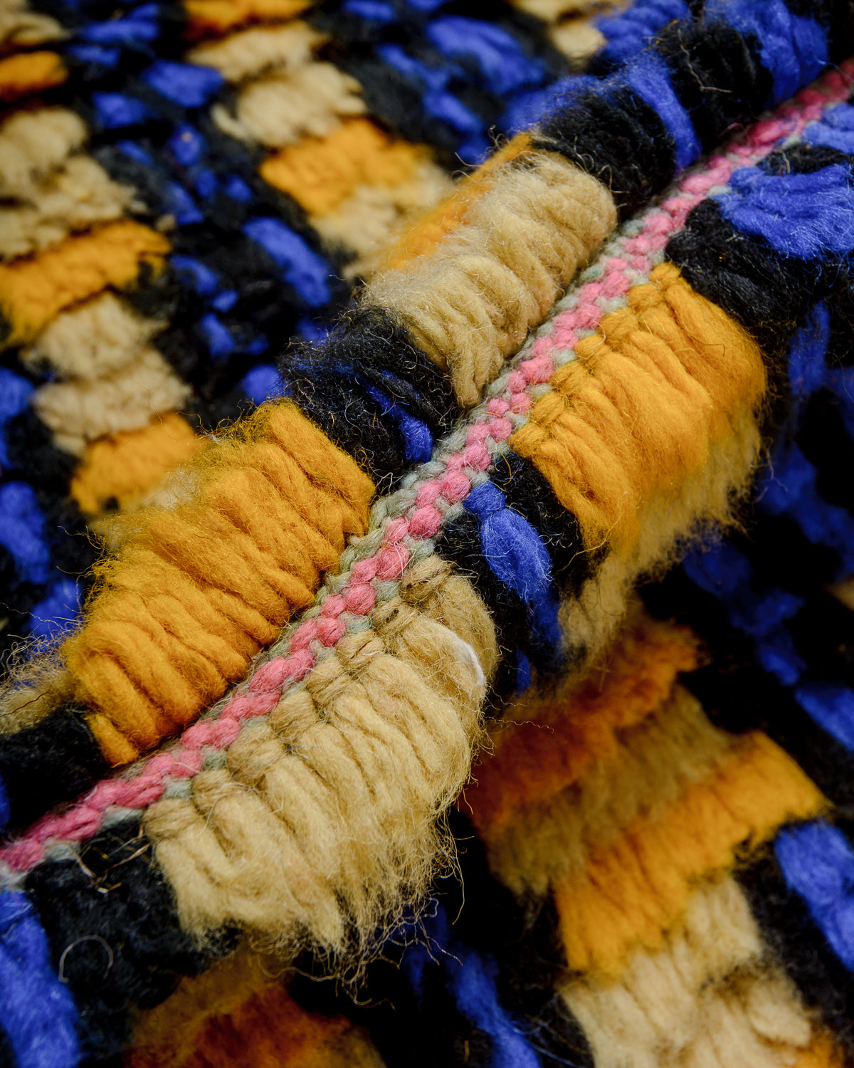 Detail of colourful berber rug showing the density of the knots and the length of the wool.