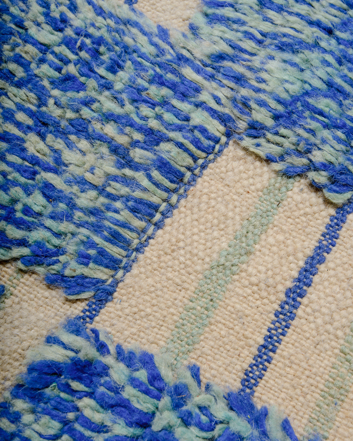 Texture of blue and turquoise berber rug showing knotted and flat-woven areas.