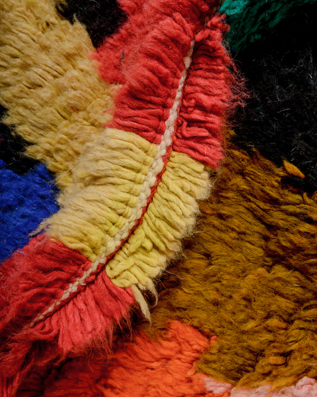 Detail of colourful berber rug showing the density of the knots and the length of the wool.