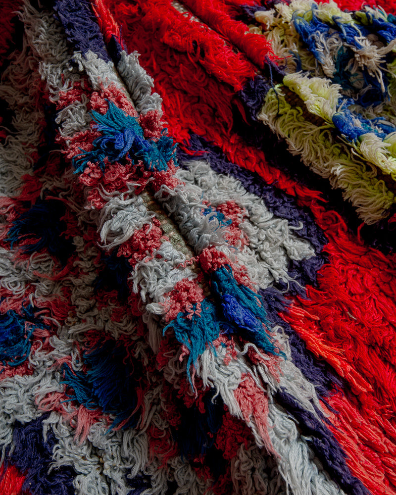 Close up of boucherouite rug with red, yellow, blue and purple cotton.