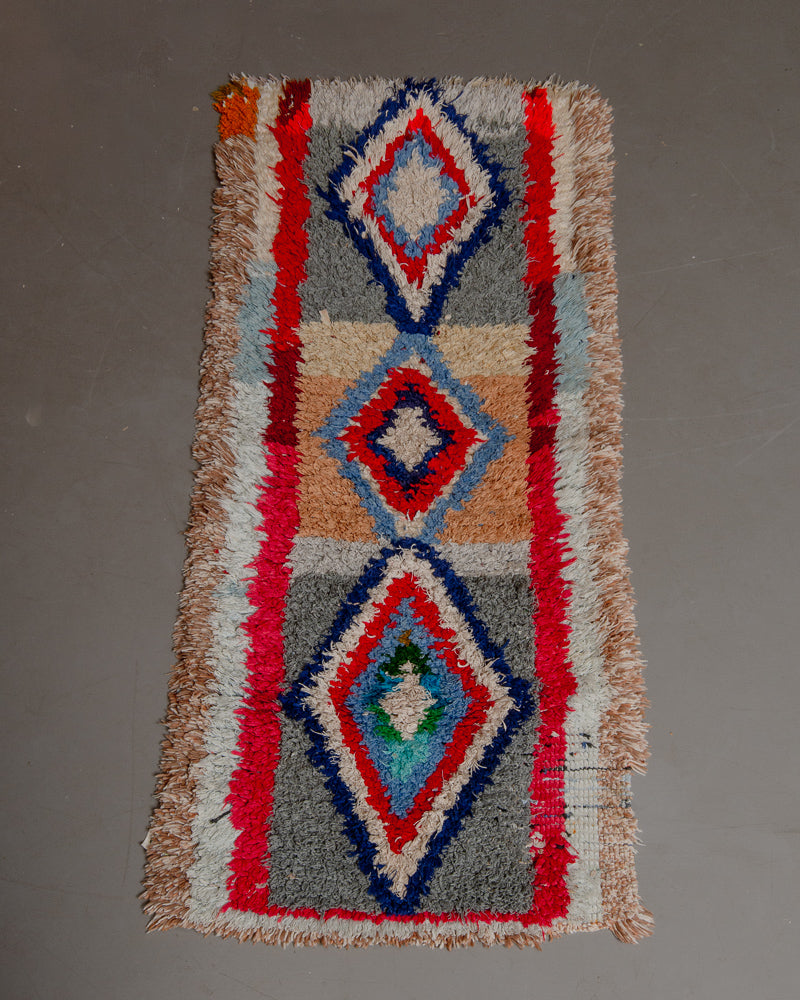 Vintage Berberlin boucherouite runner rug on grey floor.