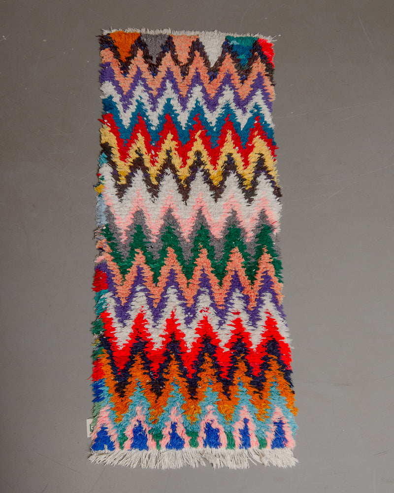 Vintage Berberlin boucherouite runner rug on grey floor. 