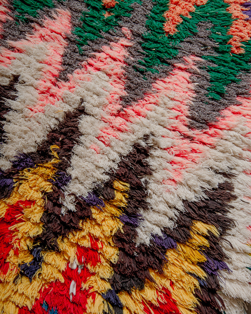 Surface of boucherouite rug with colourful cotton zigzag pattern.