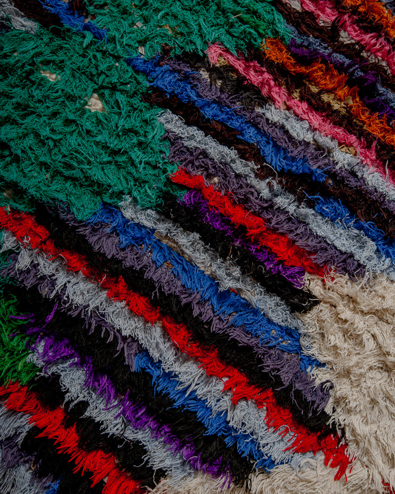 Surface of boucherouite rug with colourful cotton striped pattern.