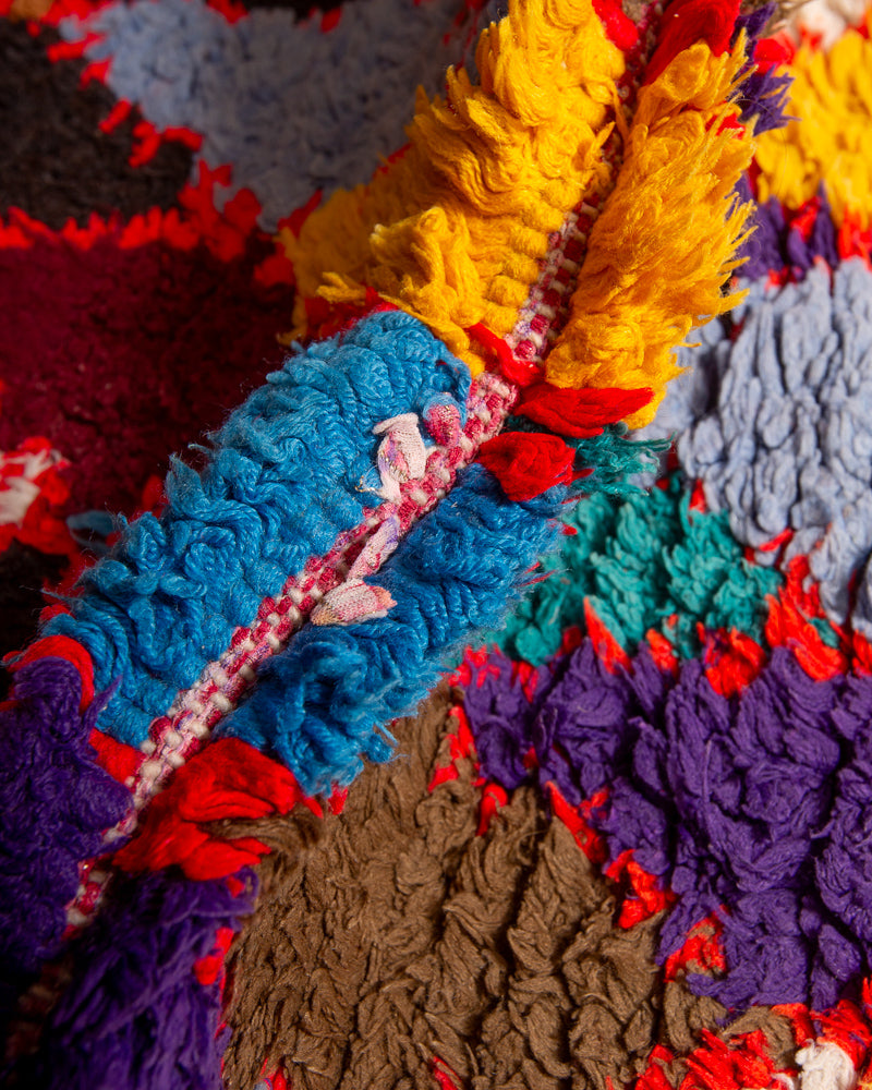 Close up of boucherouite rug with red, blue, purple and brown yarn.